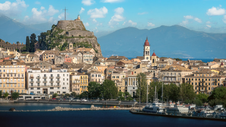 Historic Corfu Old Town from the water, with a large rock and a protruding clocktower