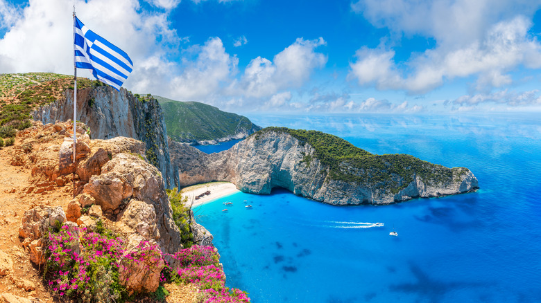 A view of Greece's Navagio Beach, aka Shipwreck Beach, from the second, unofficial viewing point, marked by the Greek flag