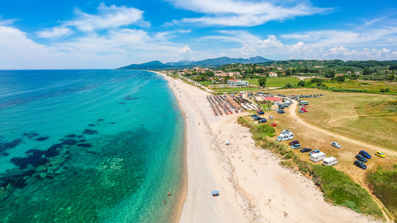 Long stretch of Monolithi Beach seen from above lapped by turquoise water in Greece
