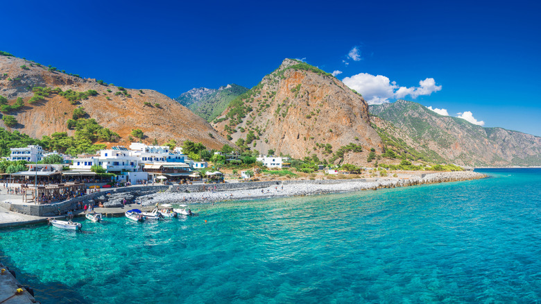 Whitewashed village of Agia Roumeli with mountains behind and sea in front.
