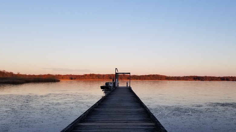 A wooden jetty extending into Dundee Creek during sunset Marshy Point Nature Center in Marshy Point Park, Maryland