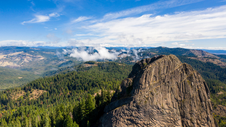 Pilot Rock outcropping surrounded by pines and tall mountains at Cascade–Siskiyou National Monument in Oregon.