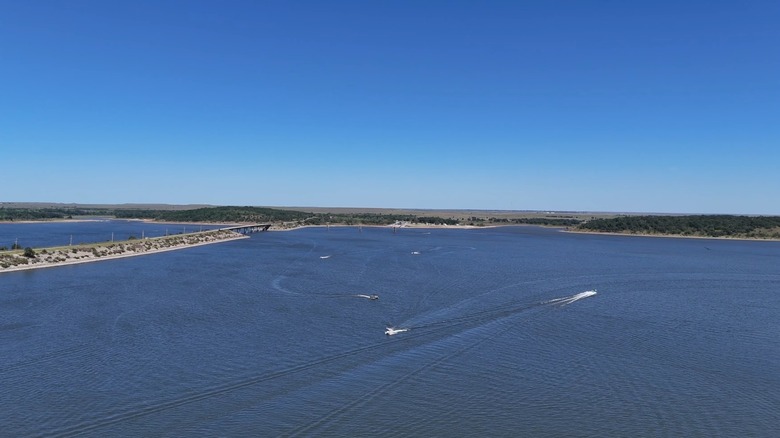 A wide aerial view of Kaw Lake with boats and a green shoreline
