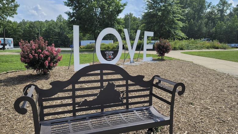 A giant sign reading LOVE next to a metal bench at New Kent East Rest Area