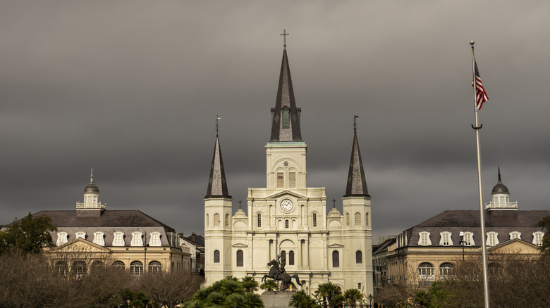 Buildings by Jackson Square in New Orleans with dark clouds
