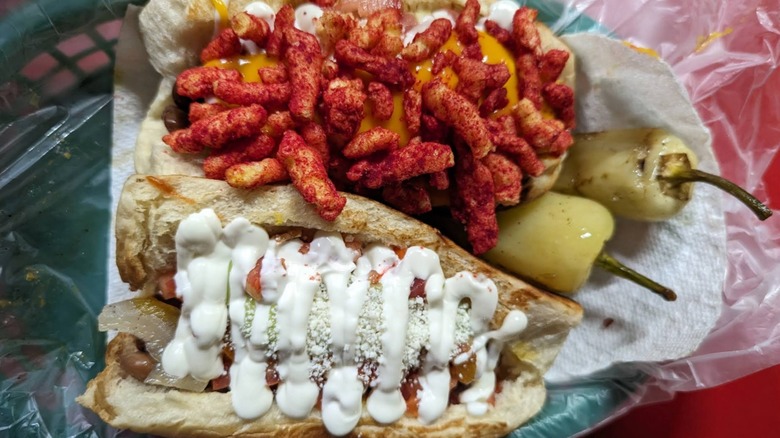 Hot cheetos on Sonoran hot dog in basket with classic Sonoran hot dog El Caprichoso