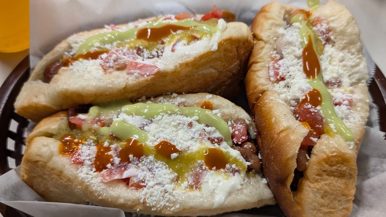 Three Sonoran hot dogs with avocado cream and cheese in black basket Nogales No. 2 Phoenix