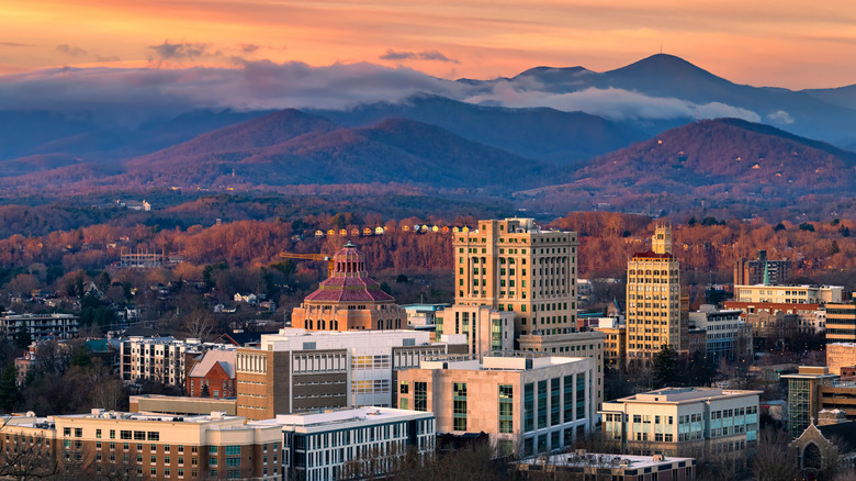 The Asheville skyline with mountains in the background at sunset