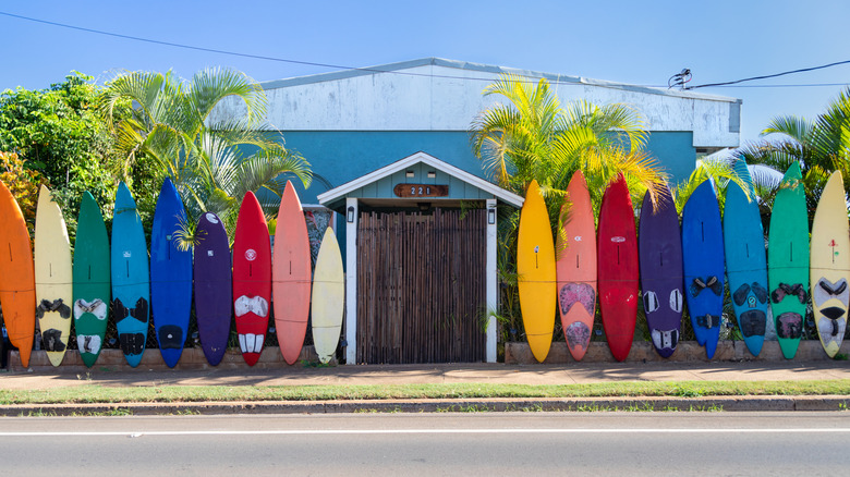 Colorful surfboards between a shop entrance along a street