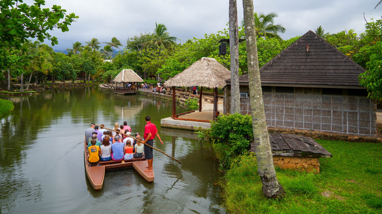 Tourists on a catamaran river cruise at the Polynesian Cultural Center on the North Shore of O'ahu island in Hawaii