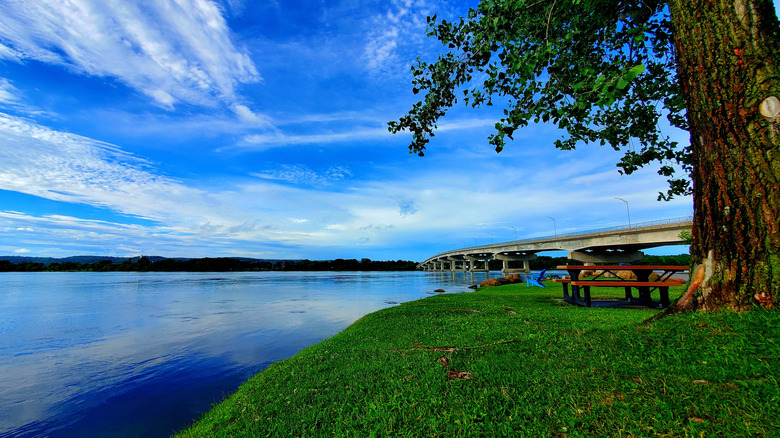 Riverside park with benches and bridge