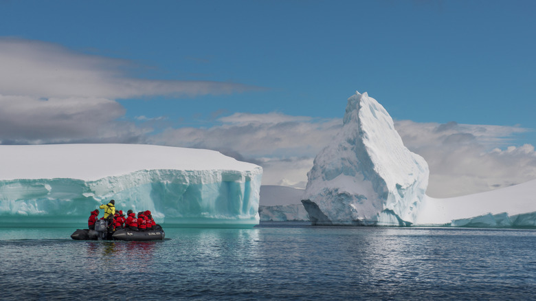 Adventurers on zodiac boat zip amid glaciers in Antarctica