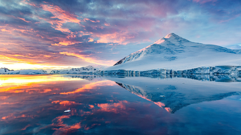 Sun sets over snowy landscape in Antarctica