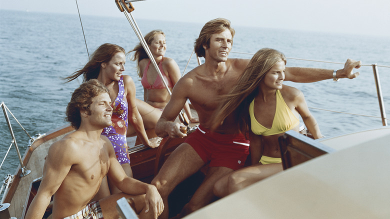 A group of young people having fun on a sailboat circa 1970s