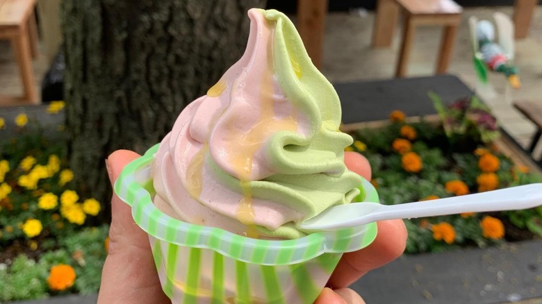 A hand holding basil and strawberry soft serve gelato at L'Industrie pizzeria in New York City.