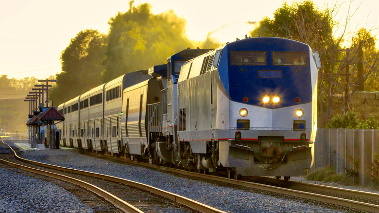 The Coast Starlight Amtrak train cruising along tracks at sunrise