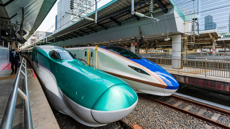 View along two bullet trains waiting at the platofrm in Tokyo. Japanese Shinkansen, E5 series at the platform and next to it a series E7 bullet train.