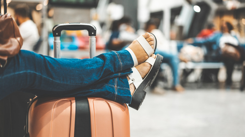 Feet in sandals on a suitcase