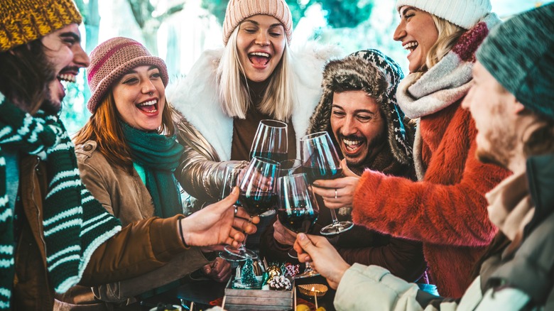 Skiers clinking wine glasses