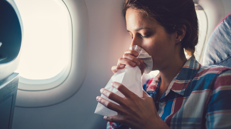 woman with air sickness bag
