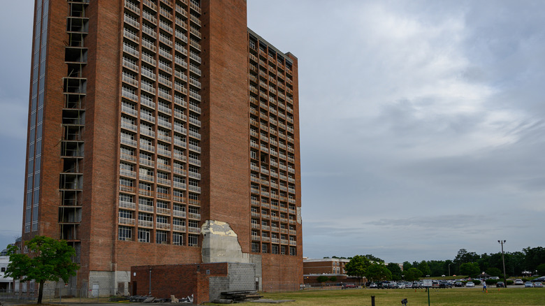 Ruined brick high rise with broken windows and bare walls Heritage Tower South Carolina