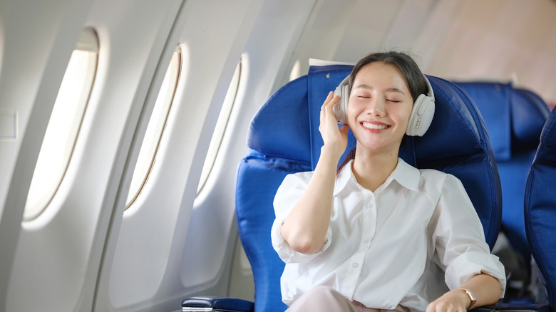 Woman on a plane with noise canceling headphones