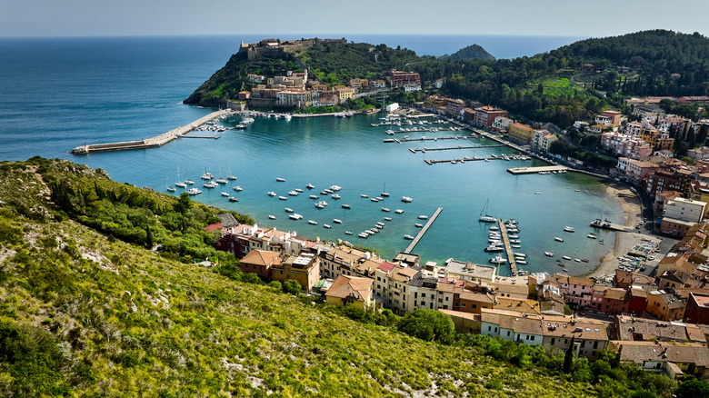 Italian harbor town with sailboats, fortresses, and blue water