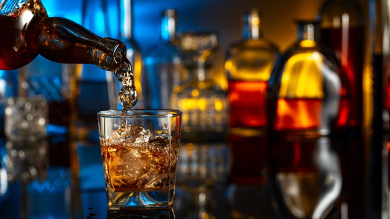 Whiskey poured into glass at bar