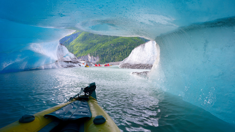 A kayak going through an ice cave with a mountain ahead