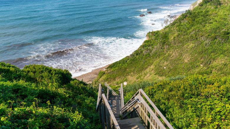 Wooden staircase leading down to the beach at Mohegan Bluffs, Block Island, Rhode Island, USA. August 2024.