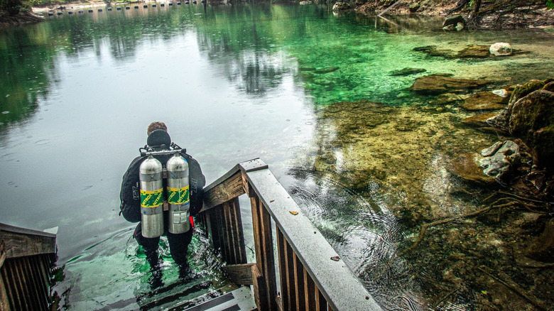 Scuba diver stands on steps leading to the water