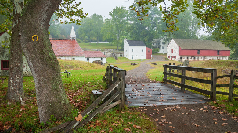 19th-century buildings and a wooden bridge surrounded by trees in the Hopewell Furnace National Historic Site