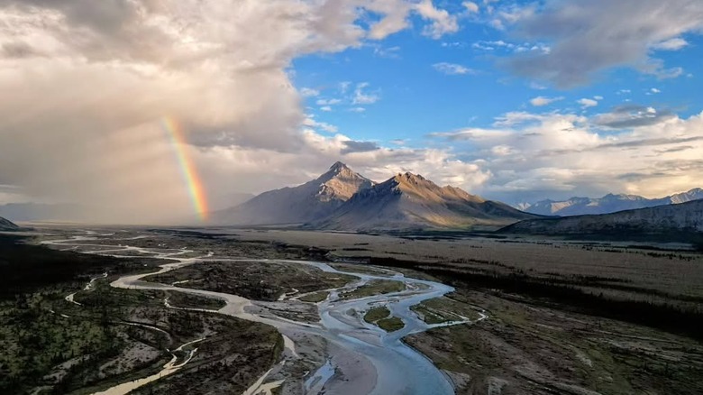 River with mountains and rainbow behind