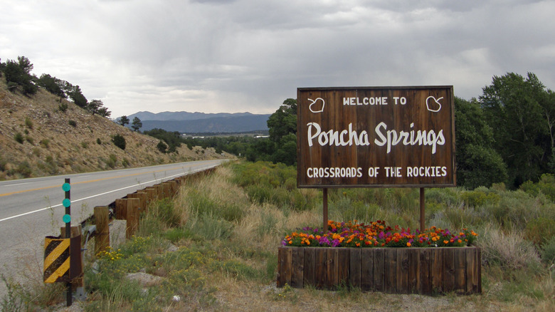 A sign that reads "Welcome to Poncho Springs: Crossroads of the Rockies"