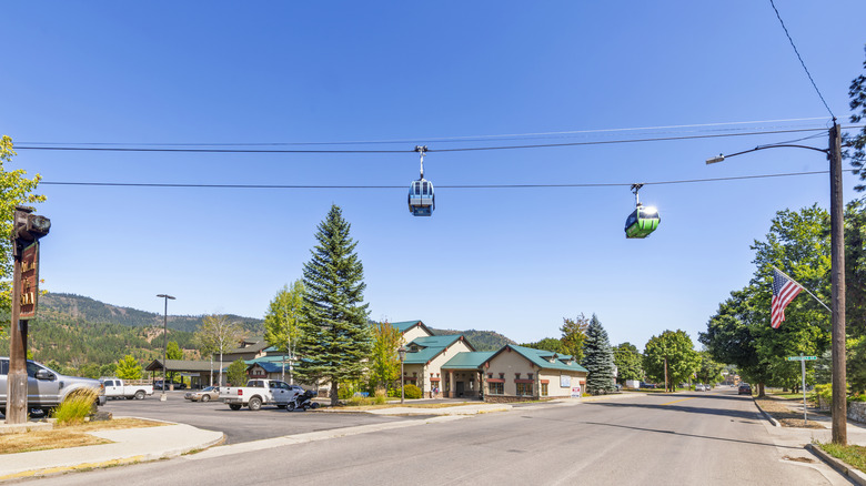 Gondola cars pass above city street in Kellogg