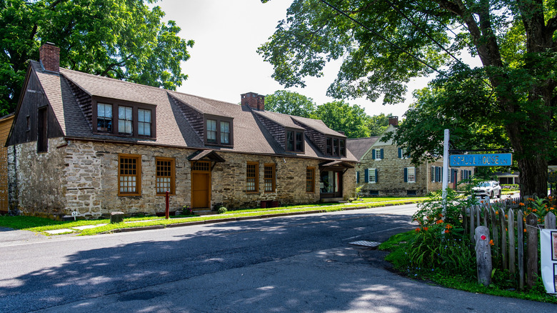 Old-world stone and timber houses along a quiet, tree-lined street in Hurley, New York.