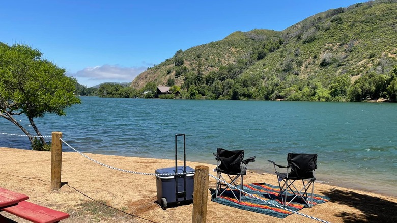 Tow camping chairs on a sandy beach at Blue Lakes in Lake County, California.