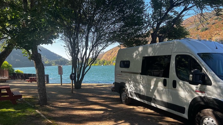 A white camper van parked at a lakefront camp site at Blue Lakes in Lake County, California.