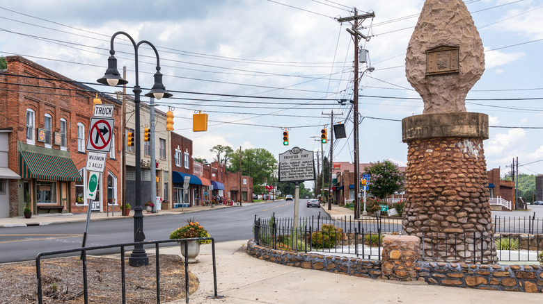 Buildings in downtown Old Fort with historical statue on display.