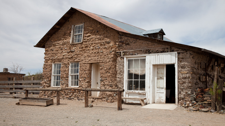 Adobe building with white wooden door in Shakespeare, New Mexico