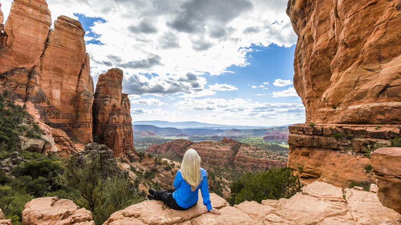 Woman sitting on a red rock overlook in Sedona, Arizona