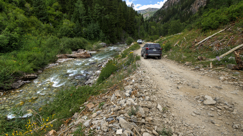 Vehicles driving along the rocky road to Crystal City ghost town