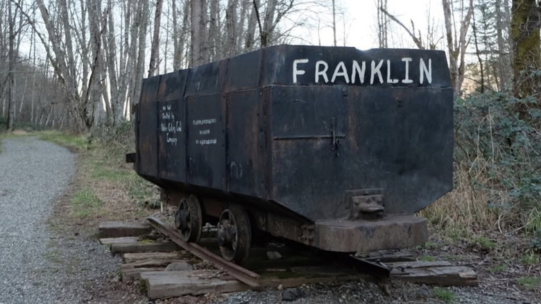 Abandoned coal car emblazoned "Franklin" in misty Washington woods
