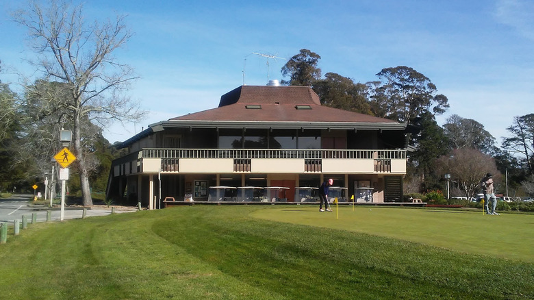 People playing golf in front of the clubhouse at DeLaveaga in Santa Cruz, California