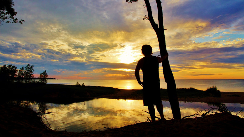 Man watching sunset at Port Crescent State Park in Huron County, Michigan
