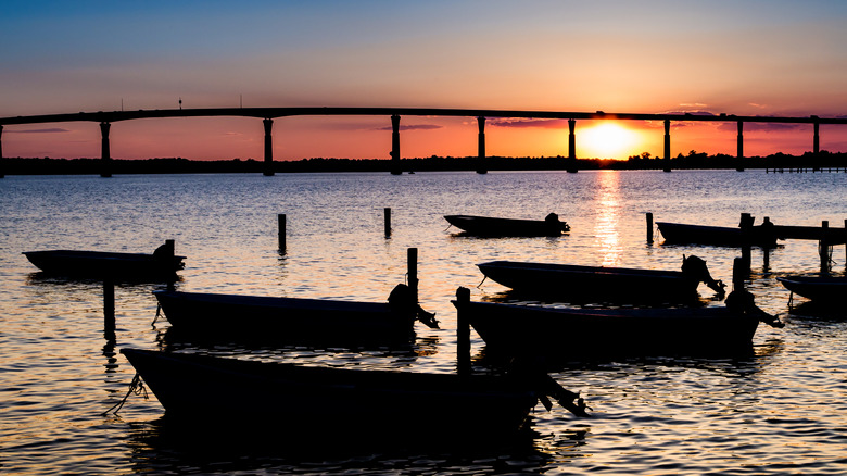 The Governor Thomas Johnson Bridge to Solomons at sunset with fishing dinghies in silhouette foreground