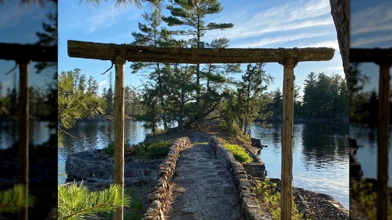Stone pathway at lake with wooden arch