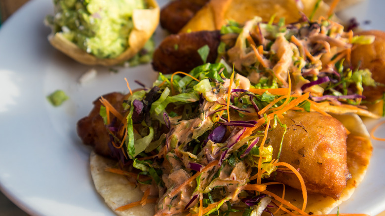 Battered fish tacos topped with slaw and salsa
