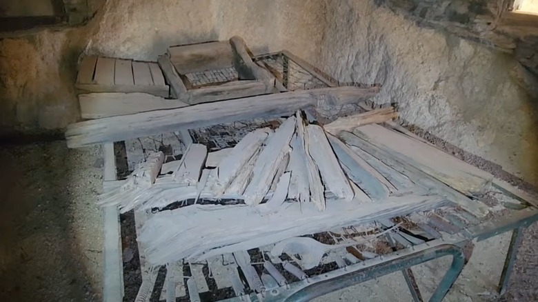 1930s bed cot with wood on top in cave
