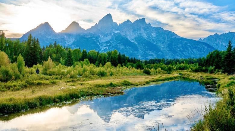 View of Schwabacher Landing in Grand Teton National Park, Wyoming, with still water reflecting the Teton Range at sunrise